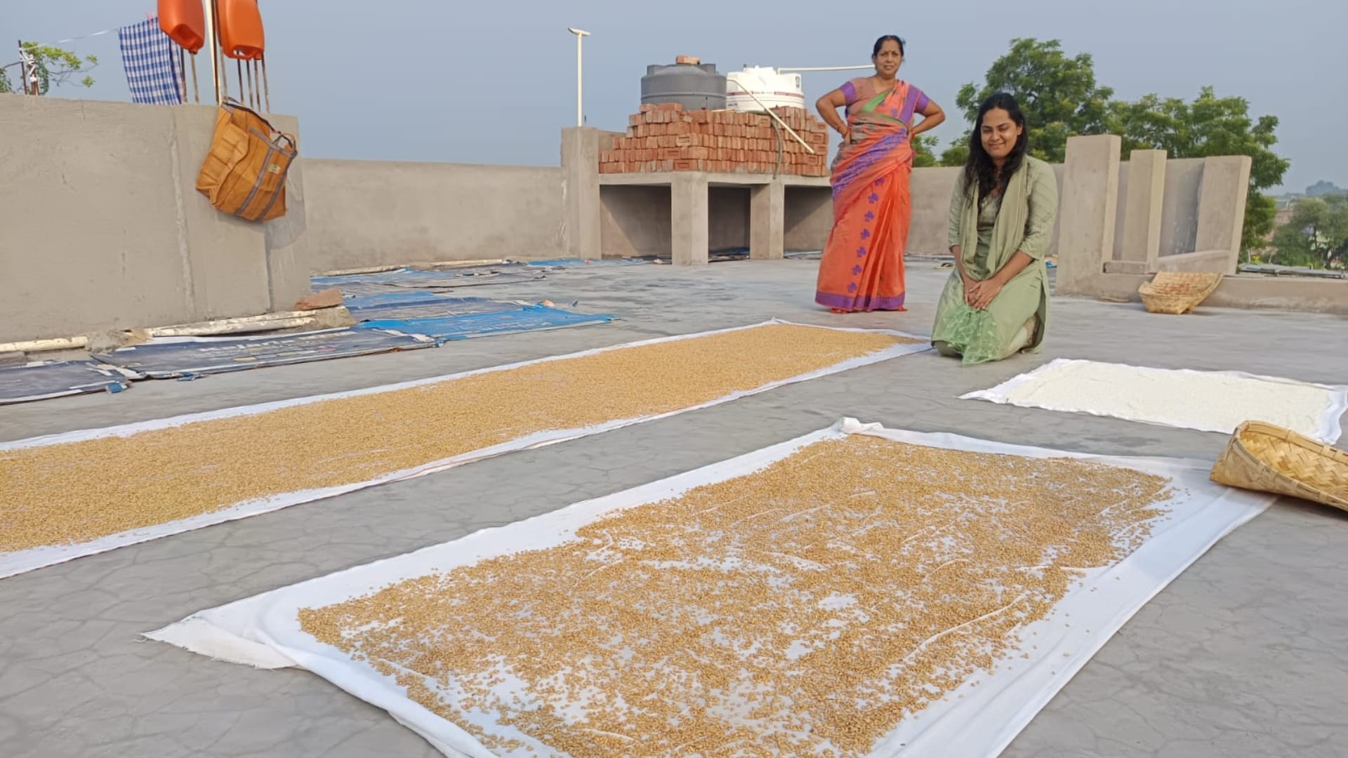 छठ पूजा प्रसाद के लिए अन्न को धोकर सुखाते व्रती और उनके परिजन।