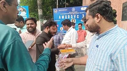 एएमयू कैंपस में मिठाई बांटता छात्र