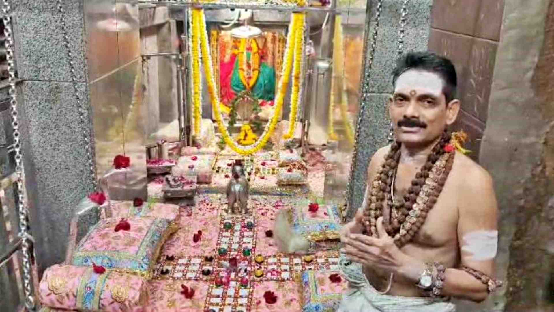 ओंकारेश्वर ज्योतिर्लिंग मंदिर में भ्रमण की जानकारी देते पुजारी