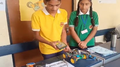 कार के मॉडल के बारे में जानकारी देता छात्र