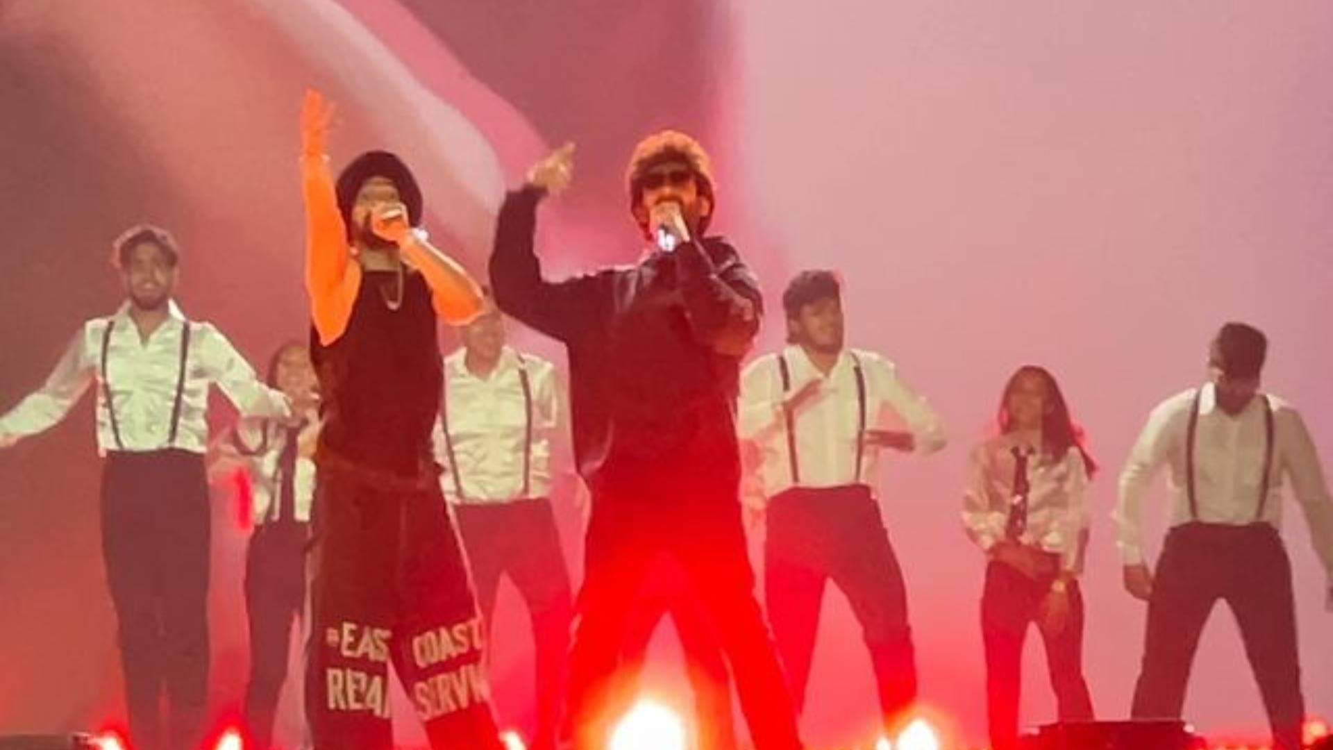 Diljit Dosanjh and Kartik Aaryan raising their hands as they twinned in black outfits at Ahmedabad show