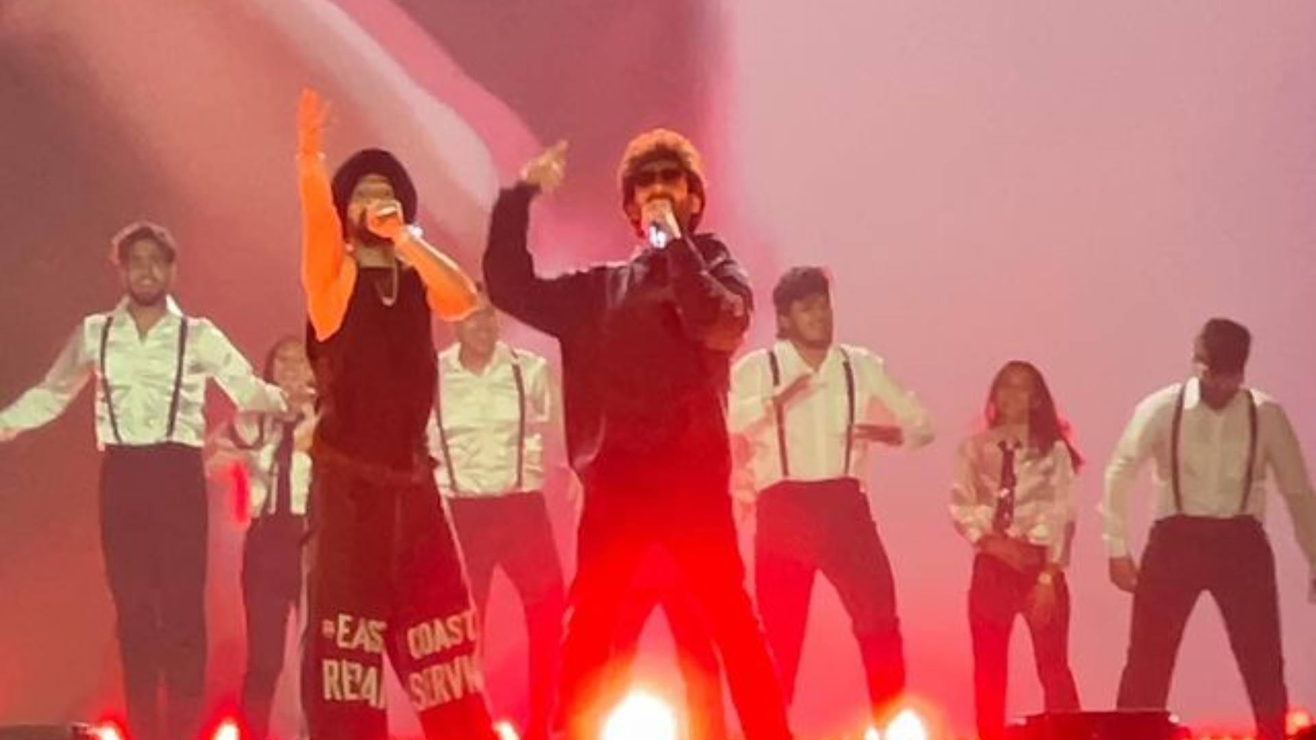 Diljit Dosanjh and Kartik Aaryan raising their hands as they twinned in black outfits at Ahmedabad show