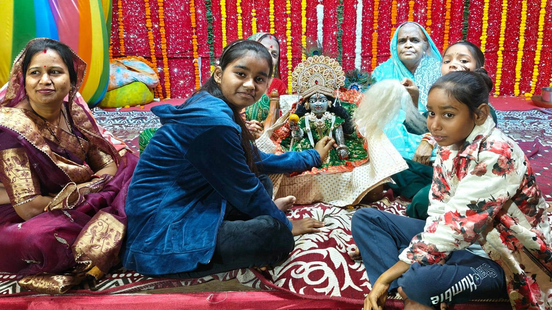 लड्डू गोपाल के पास बैठी महिलाएं और लड़कियां
