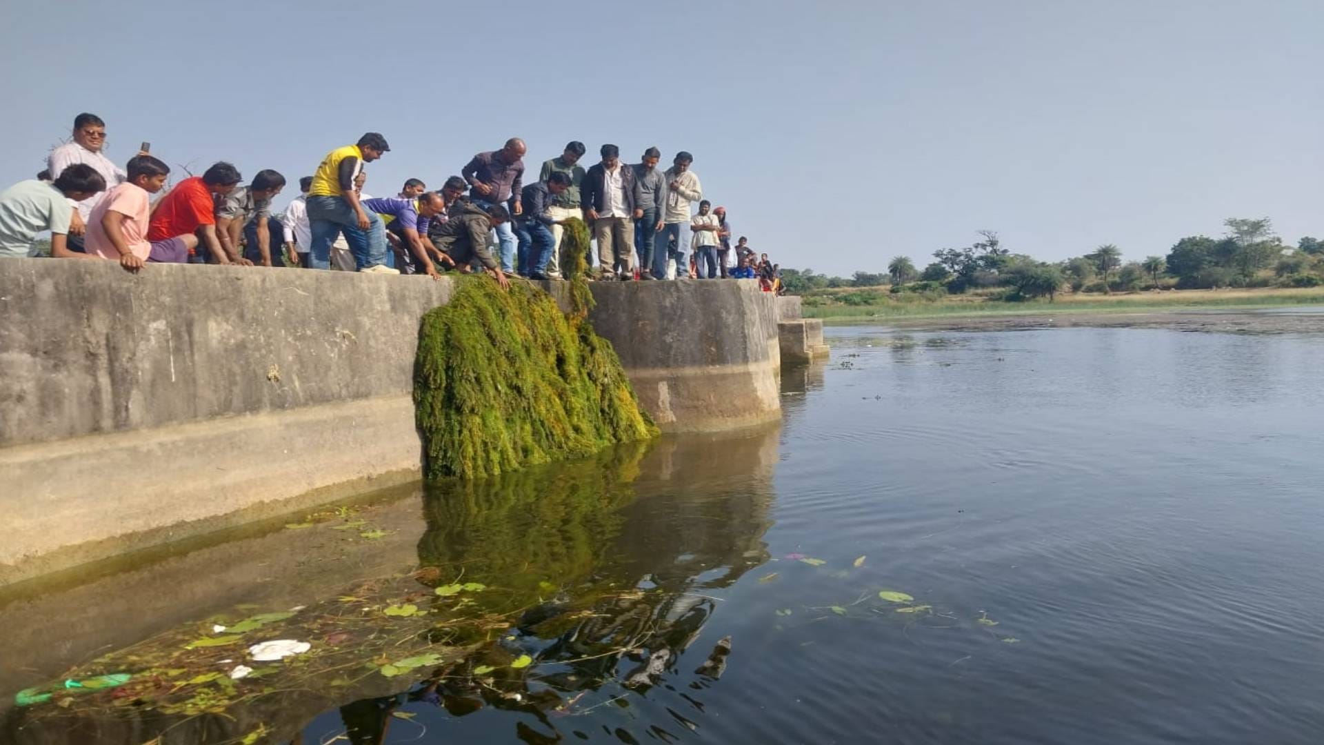 तालाब खाली करते हुए लोग