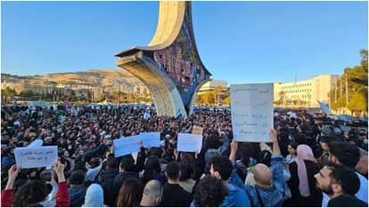 सीरिया में प्रदर्शन करते लोग।