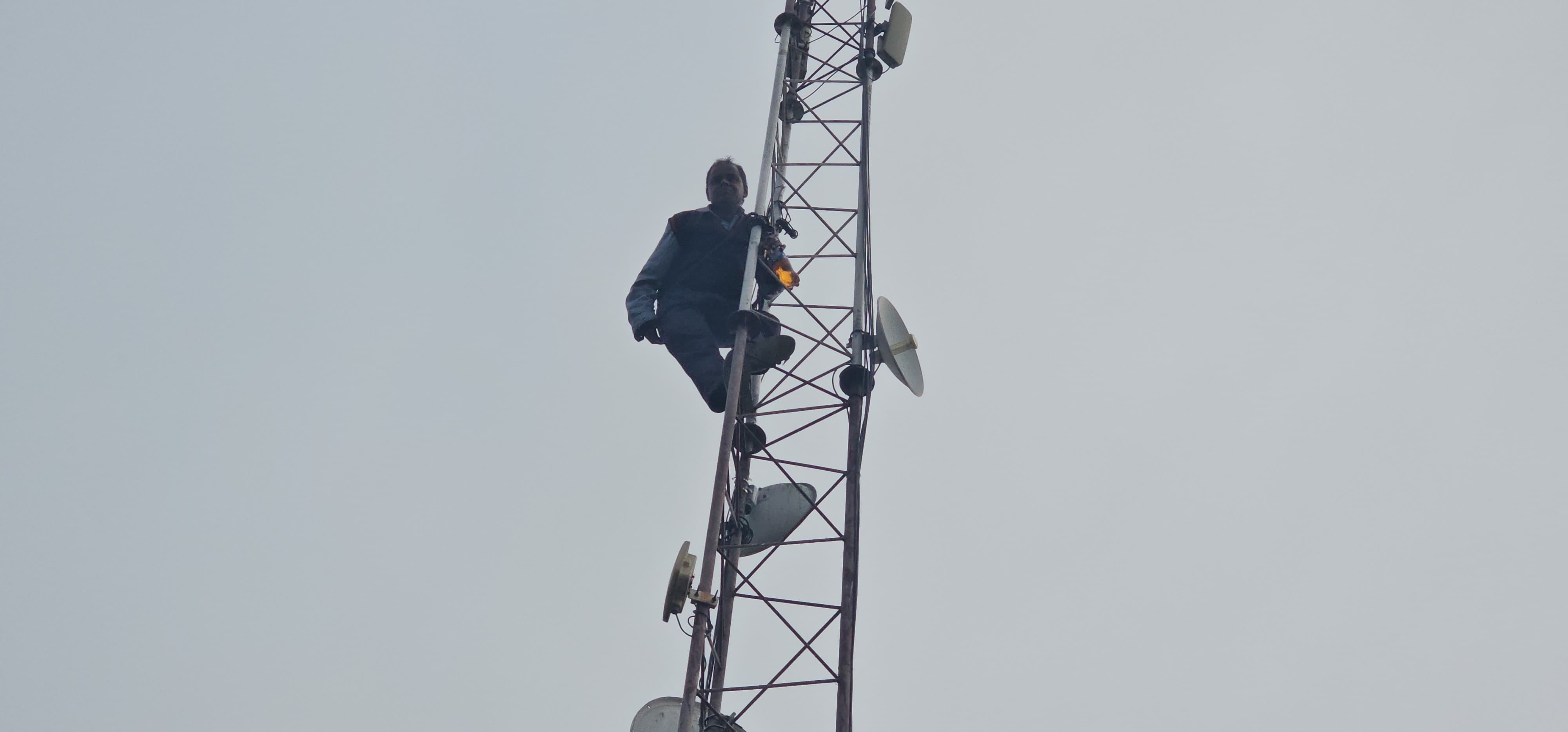 Rishikesh News Shopkeeper climbed on mobile tower with bottle of petrol crowd gathered, photos