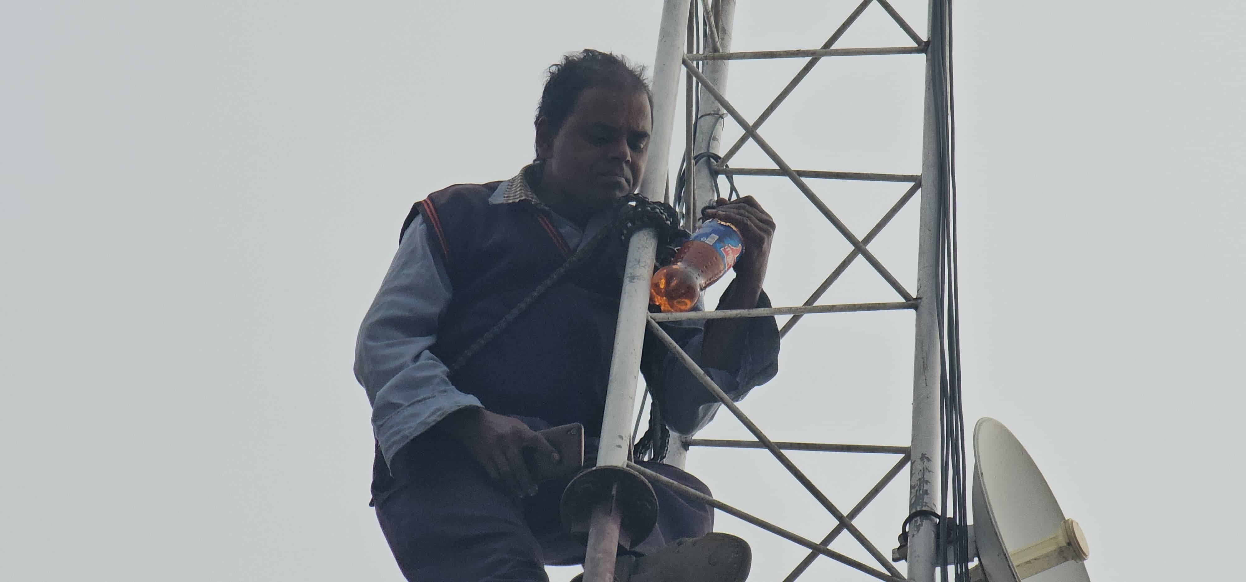 Rishikesh News Shopkeeper climbed on mobile tower with bottle of petrol crowd gathered, photos