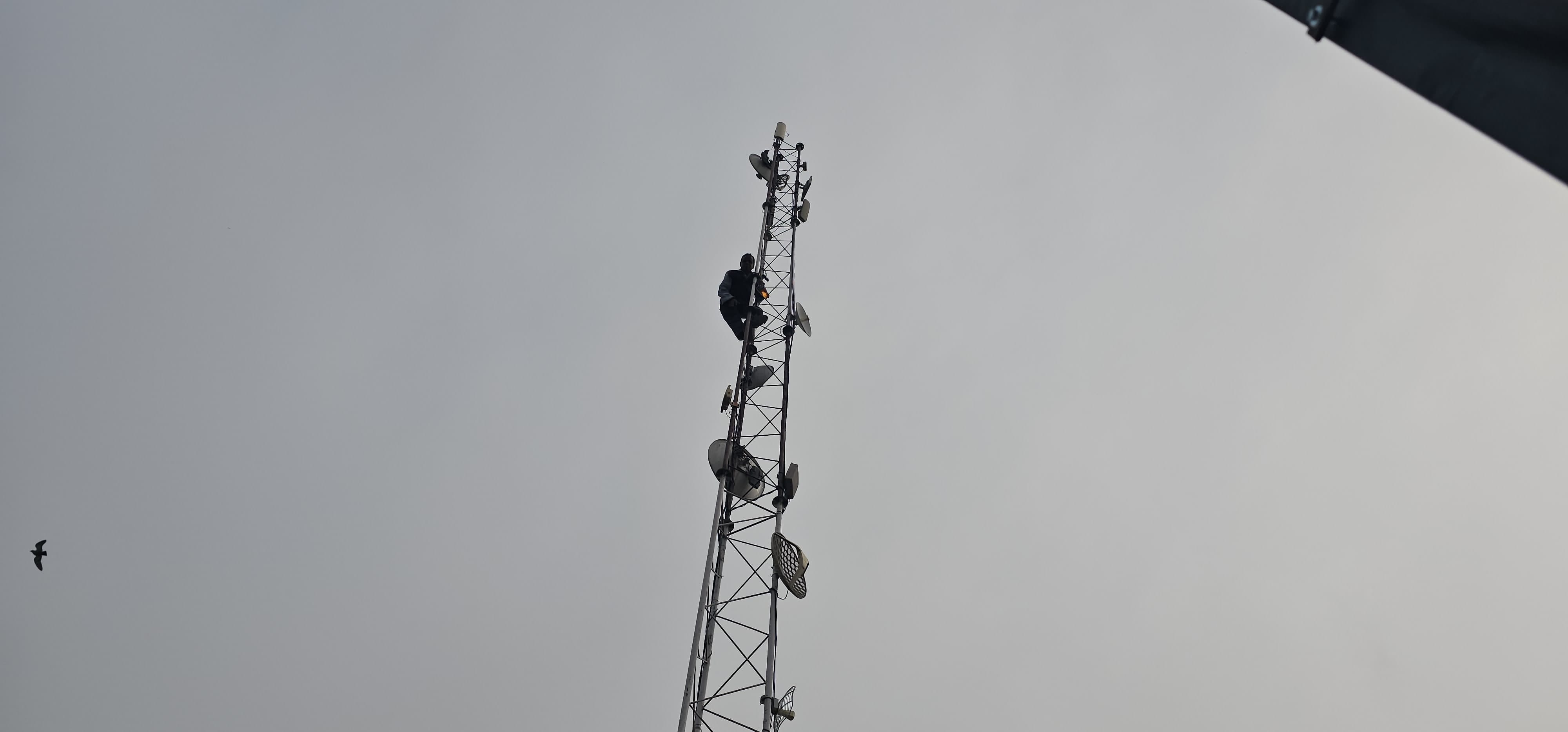 Rishikesh News Shopkeeper climbed on mobile tower with bottle of petrol crowd gathered, photos