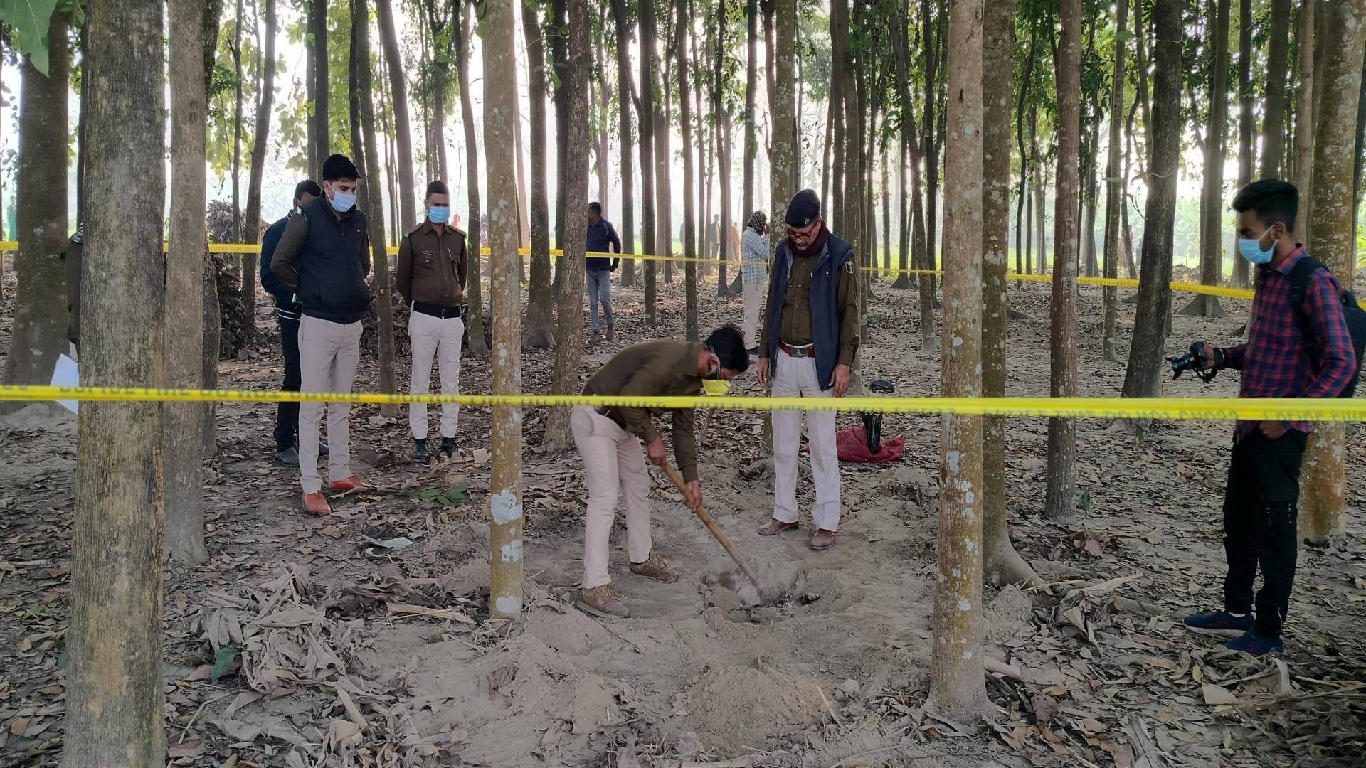 गड्ढे से शव निकालती पुलिस