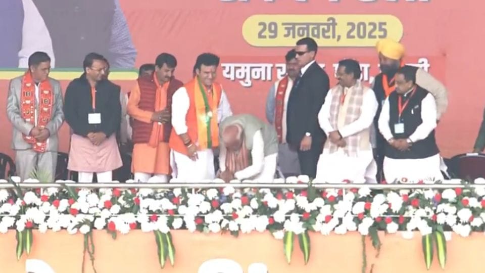 Delhi Assembly Elections PM Narendra Modi touched feet of Ravindra Singh Negi on stage during rally in Delhi