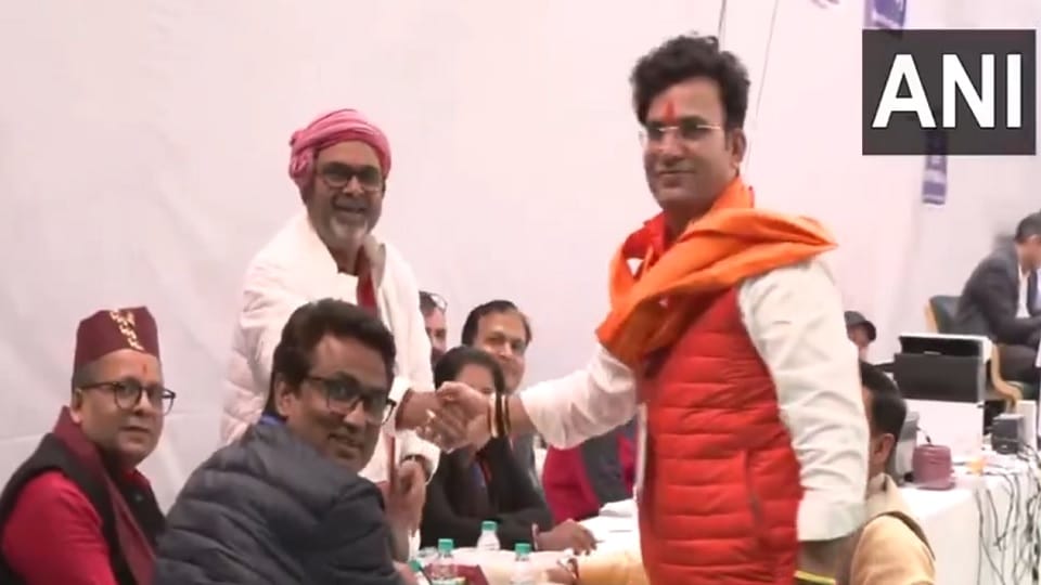 BJP's Ravinder Singh Negi from Patparganj assembly seat shakes hand with AAP's candidate Avadh Ojha