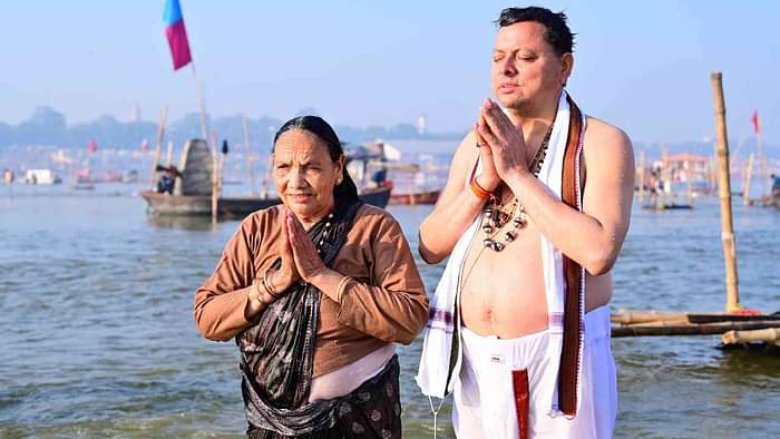 CM Dhami took a dip at Triveni Sangam in Prayagraj Maha Kumbh made his mother take a bath Watch Photos