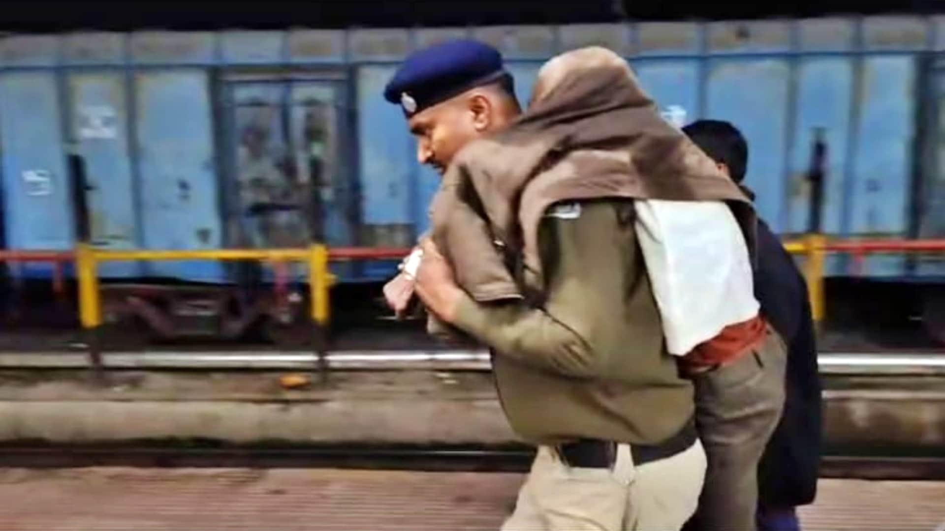 अपने कंधे पर उठाकर यात्री को अस्पताल ले जाते सिपाही राजेश कुमार सिंह