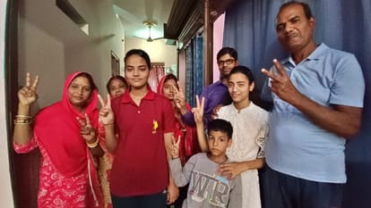 परिवार के साथ विजय चिन्ह दिखातीं टॉपर कृतिका शर्मा