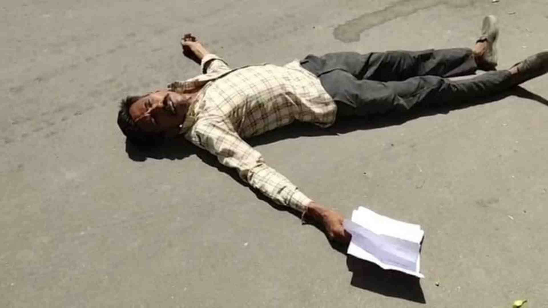 एसपी ऑफिर के बाहर सड़क पर लोटकर प्रदर्शन करता व्यक्ति।