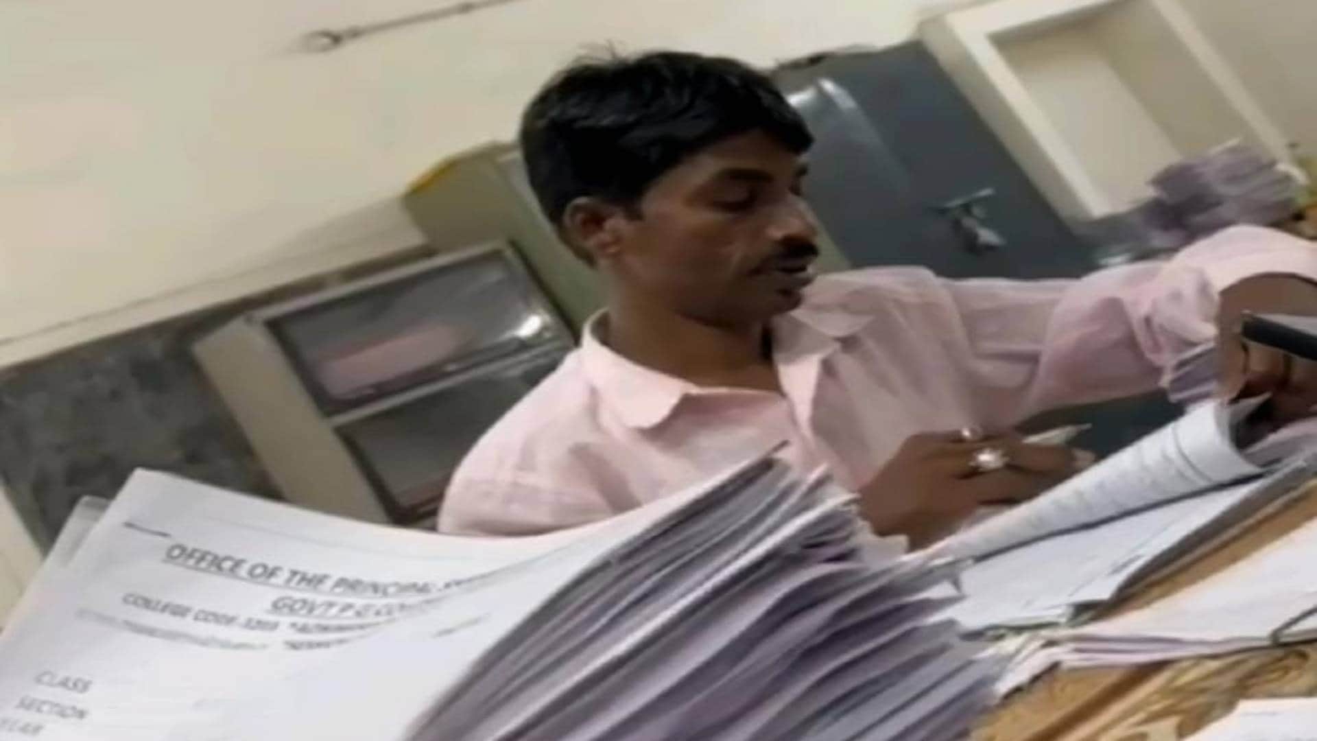 कॉपियां चेक करता हुआ चपरासी