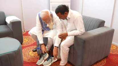 रामपाल कश्यप को जूते पहनाते पीएम मोदी।