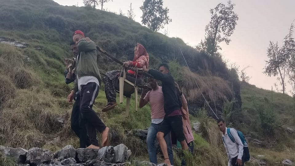 woman was taken to the road by tying a chair between two wooden logs in bageshwar