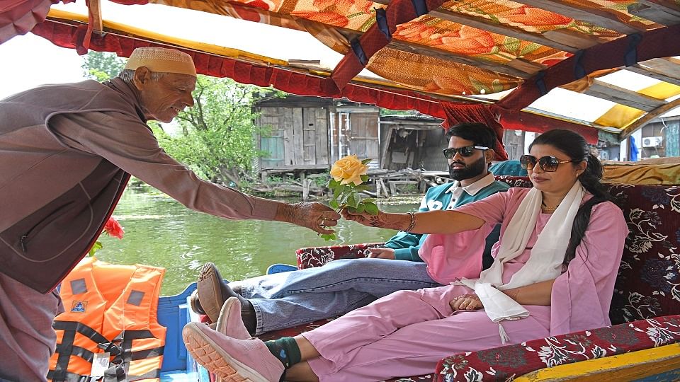 पर्यटक को फूल देते बुजुर्ग
