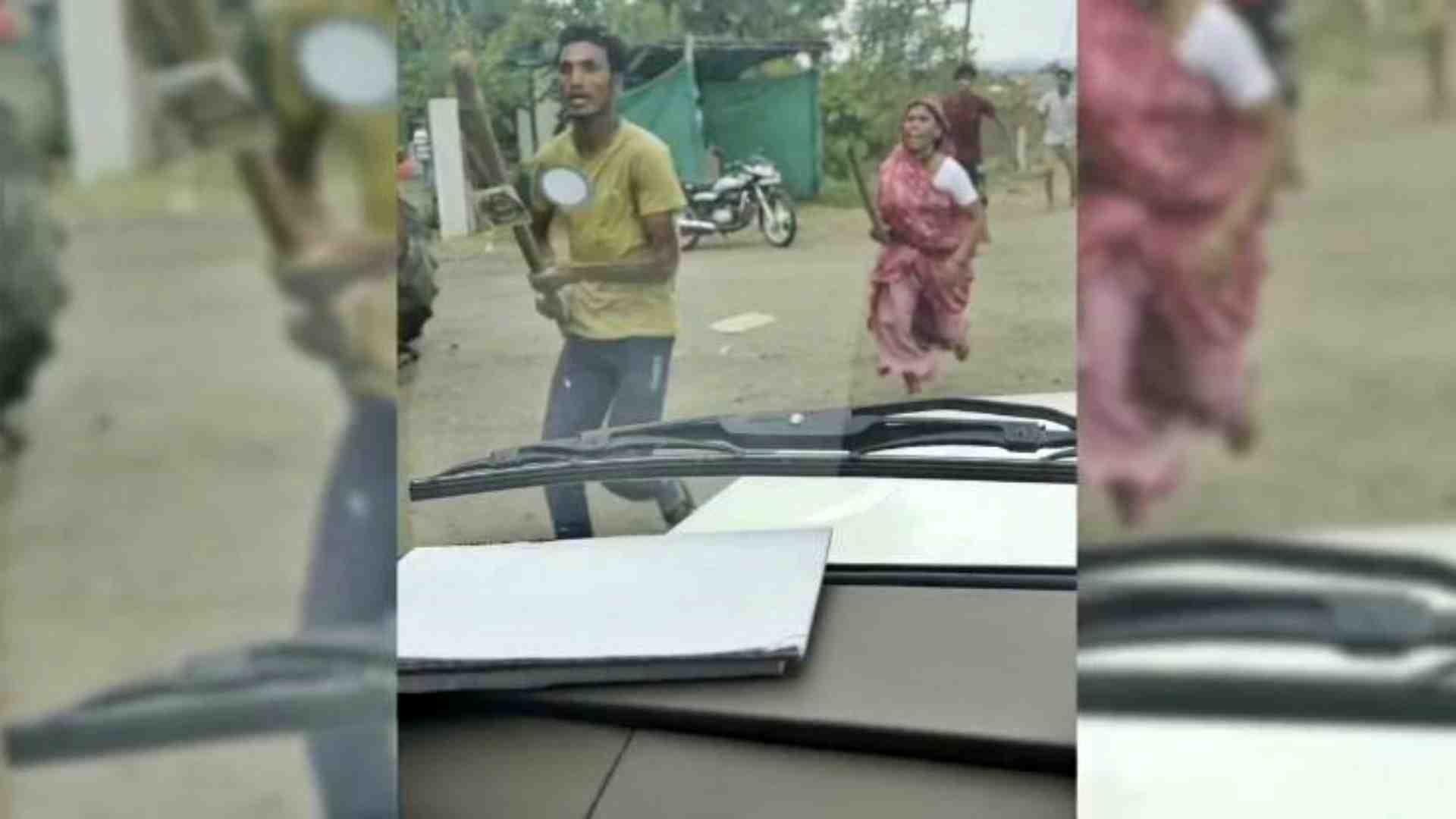 लाठी लेकर हमला करते अतिक्रमणकारी।