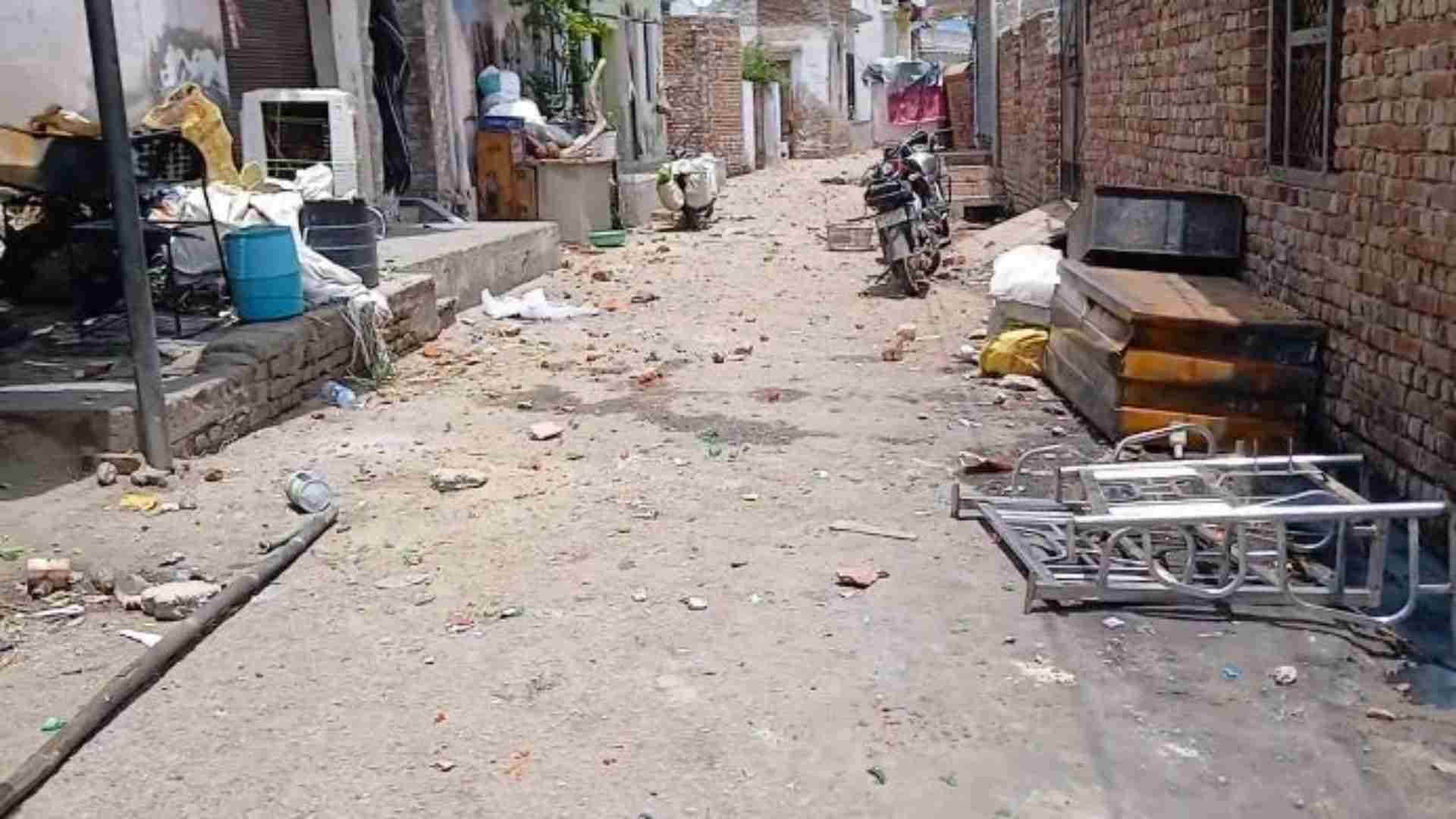 सड़क पर बिखरी ईंट-पत्थर और टूटी बोतलें।