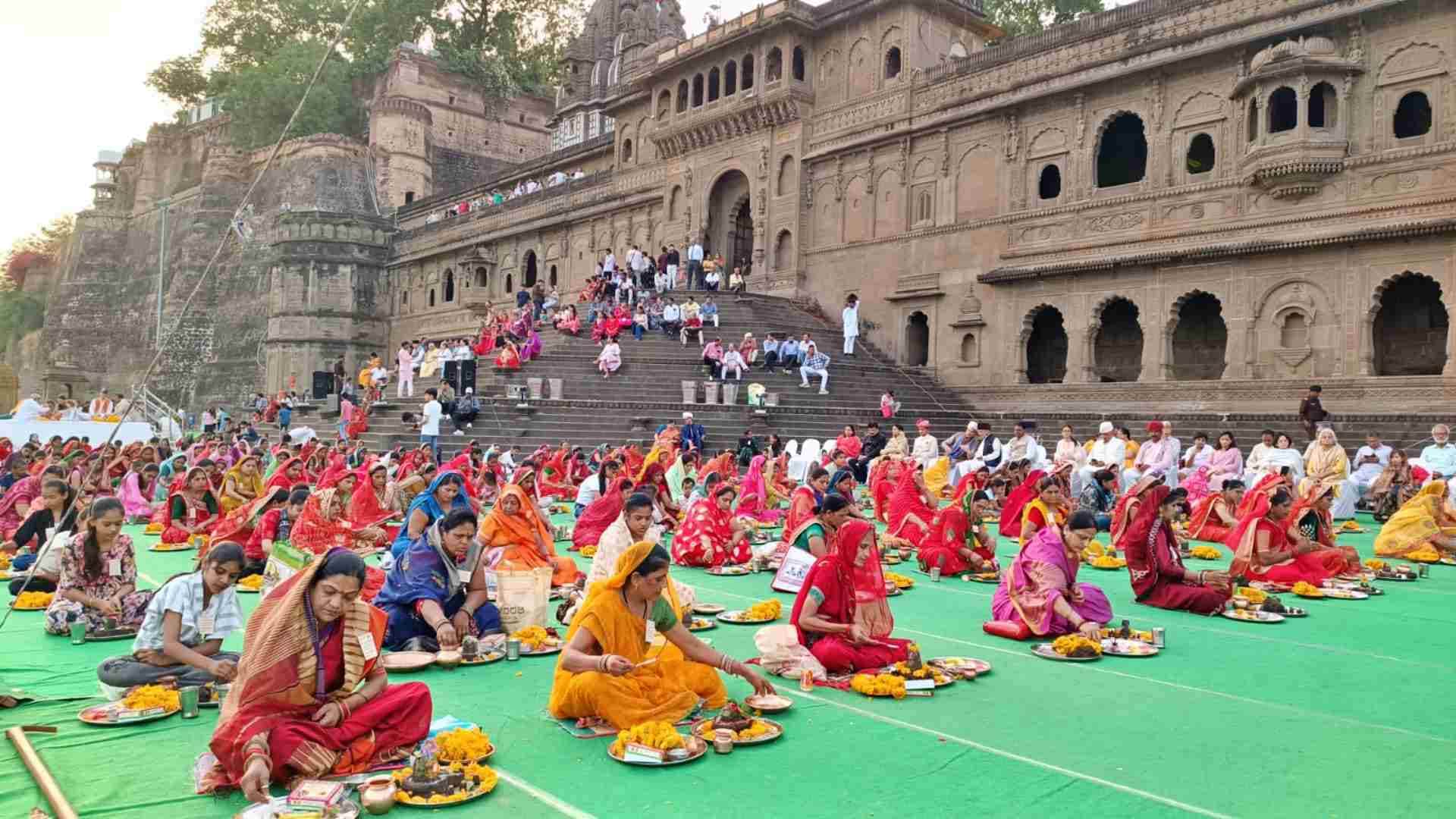 महेश्वर अहिल्या घाट पर पार्थिव शिवलिंग बनातीं महिलाएं।