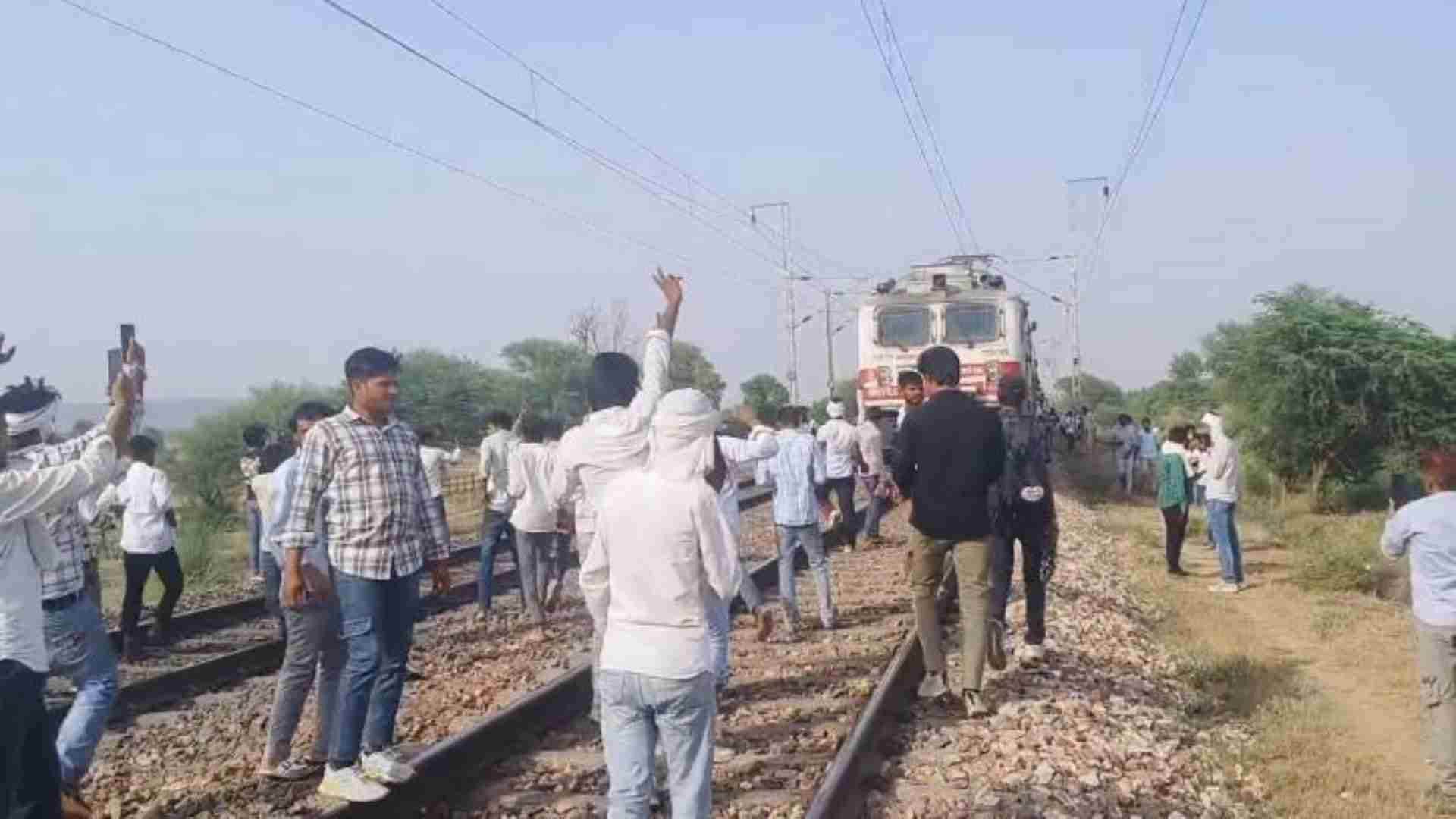 रेलवे ट्रैक पर प्रदर्शन करते युवा।