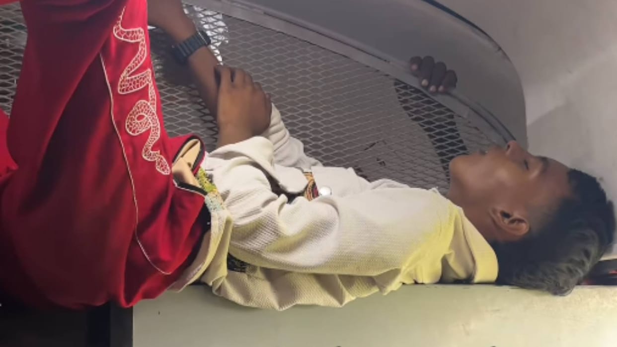 A boy put his life in danger by sleeping on the gate of a moving train Video goes Viral on Internet