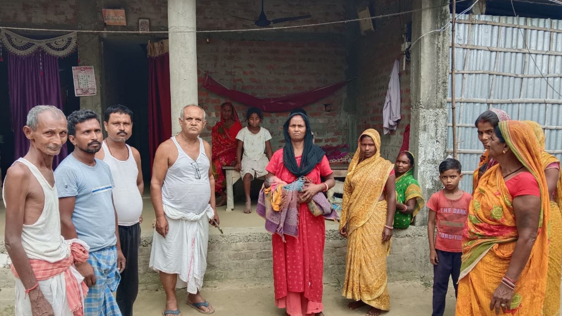गोद में नवजात को लेकर खड़ी महिला