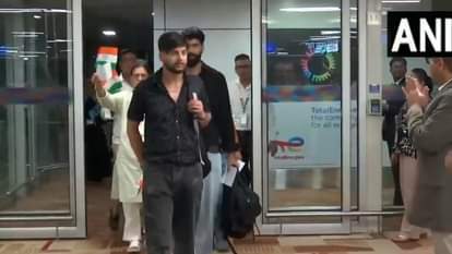 हाथ में तिरंगा लेकर एयरपोर्ट से बाहर आते भारतीय नागरिक