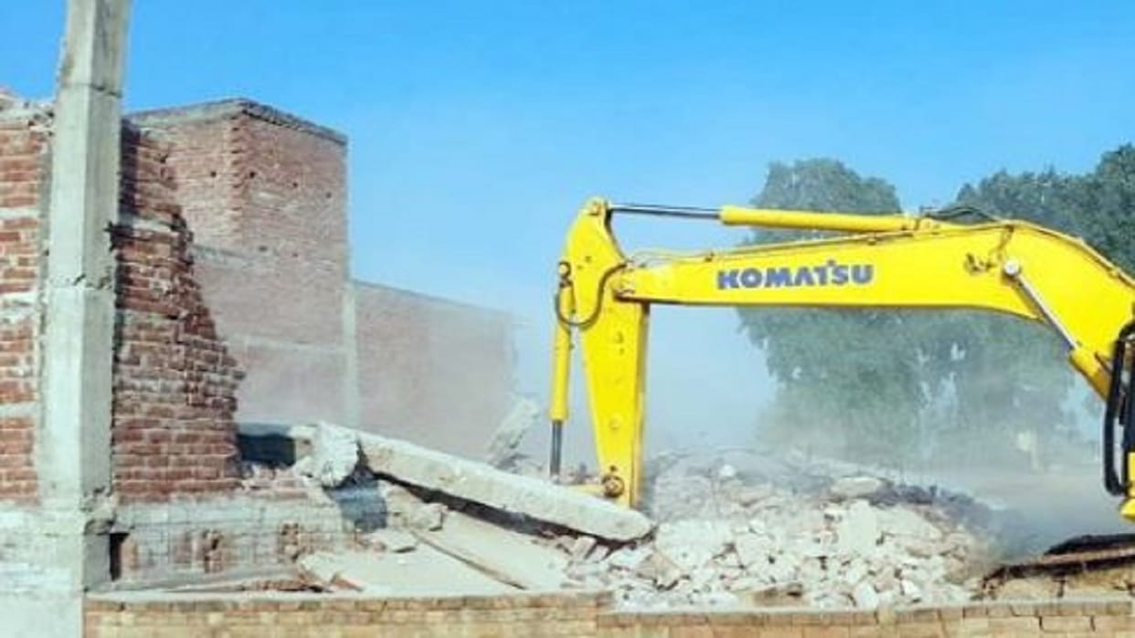 Bulldozer runs on house built on the side of the highway in Khutar