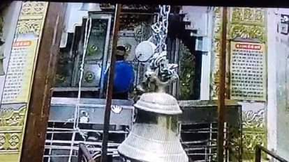 मंदिर परिसर में खड़ा चोर (नीली शर्ट)