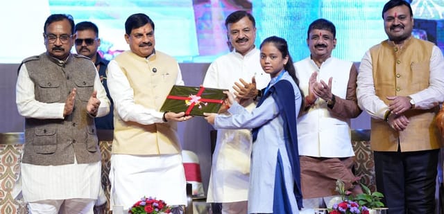 सीएम  विद्यार्थी को लैपटॉप देते हुए