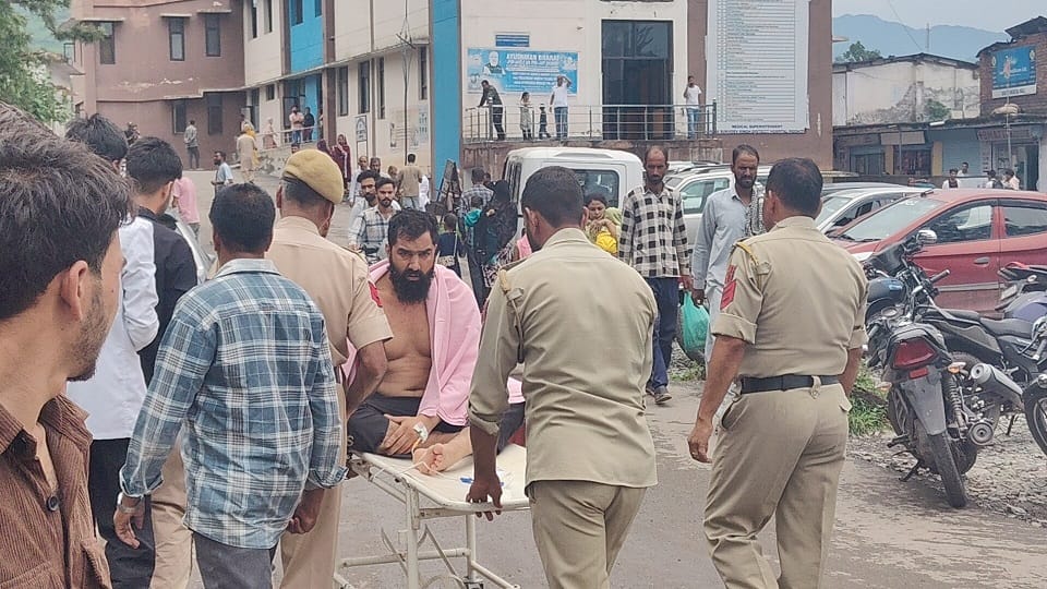 घायल कैदी को अस्पताल ले जाते पुलिसकर्मी।