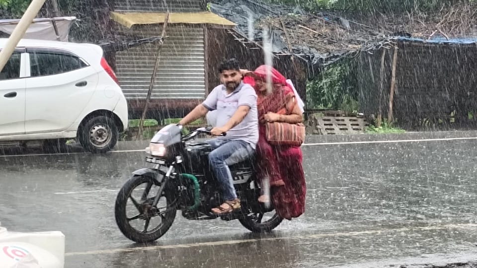 आगरा बारिश में भीगते हुए जाते बाइक सवार