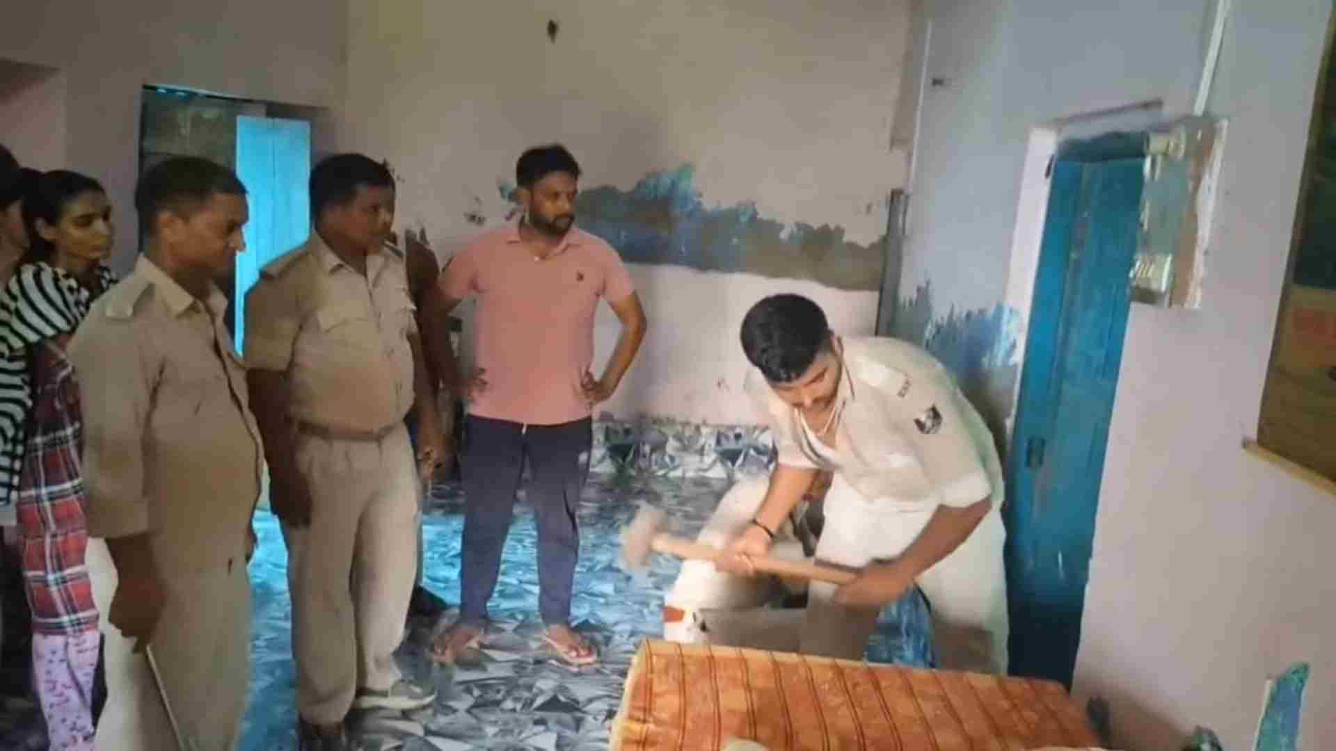 घर का ताला तोड़ती पुलिस टीम।