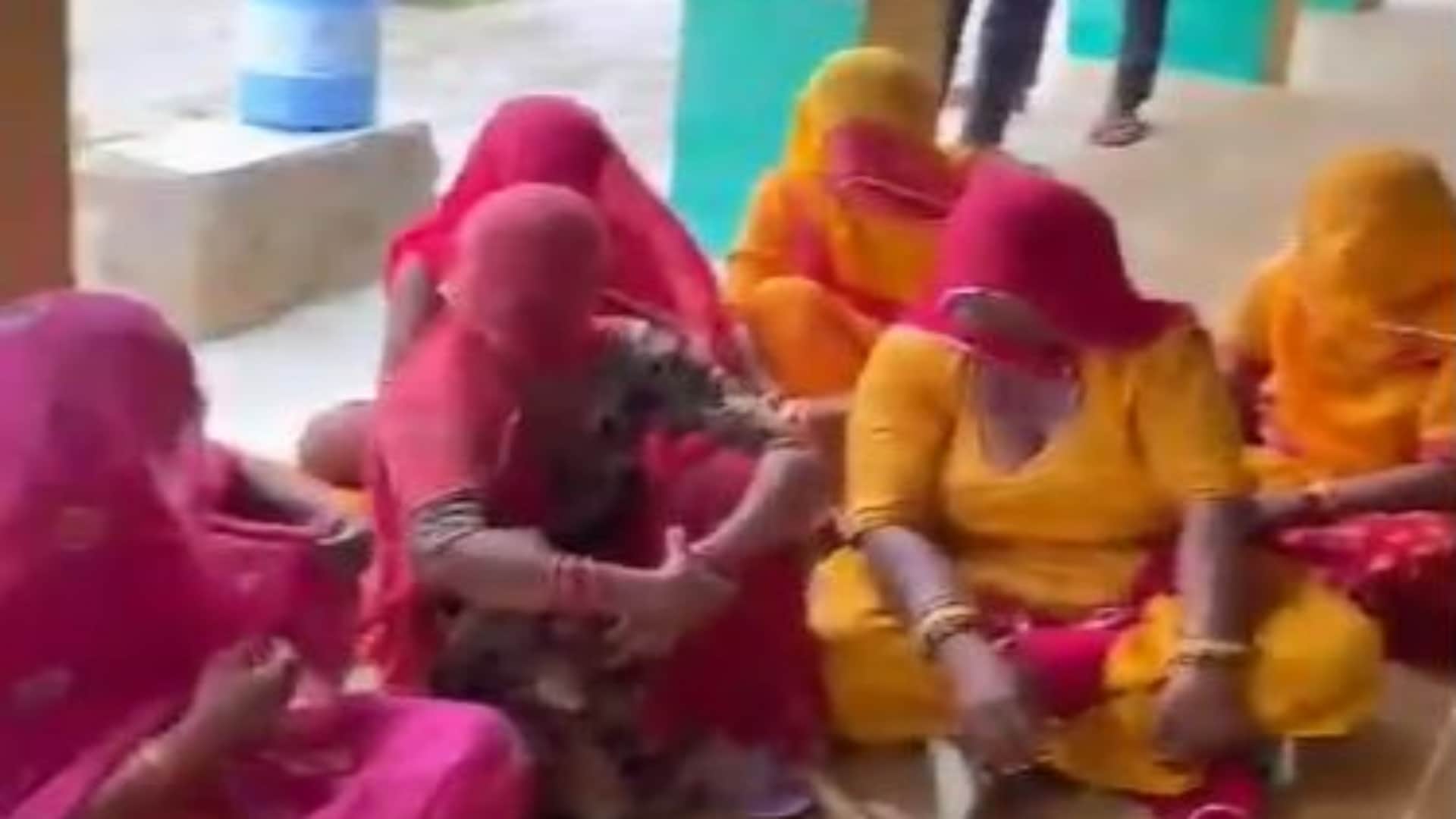 स्कूल के बाहर धरने पर बैठी महिलाएं