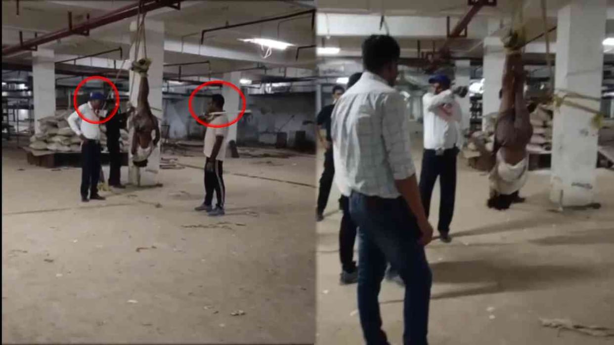 some people hanging man upside down and beating him with sticks
