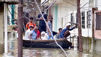 छोटा बघाड़ा क्षेत्र में बाढ़ के पानी से घर आने जाने के लिए नाव का सहारा लेते लोग