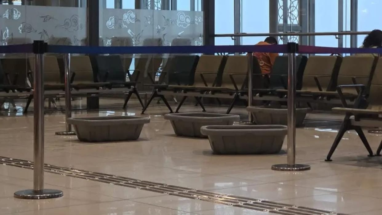 Tubs placed to protect against water dripping from the roof of Amausi Airport