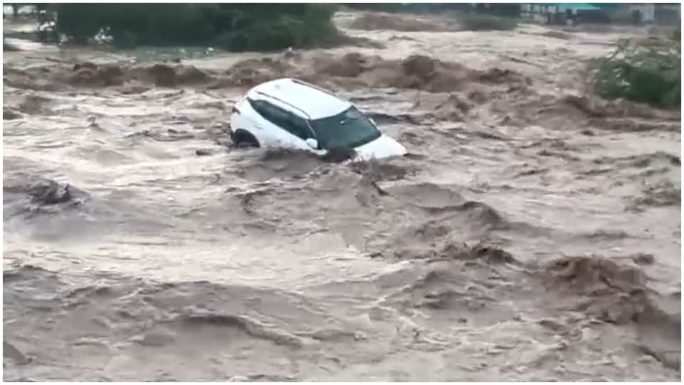 तेज बहाव में बहती कार।