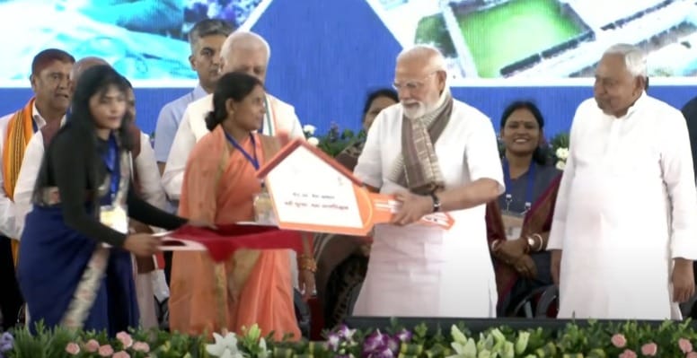 PM Modi Bihar Visit : कार्यक्रम के दौरान मंच पर पीएम मोदी महिला हितग्राही को घर की चाबी सौंपते हुए।