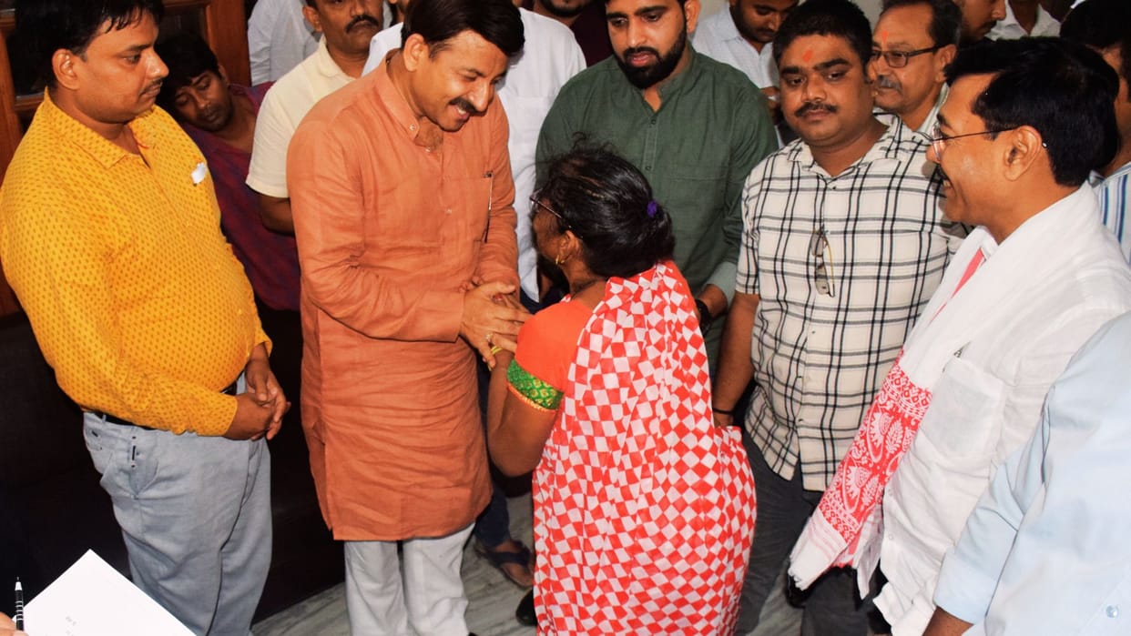 MP Manoj tiwari touched woman feet in PMO varanasi with complaint she said our case is not being heard