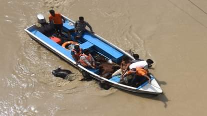 मयूर विहार यमुना खादर इलाके के  बाढ़ प्रभावित क्षेत्र में फंसे लोगों और कुत्तो को निकालते कर्मी।