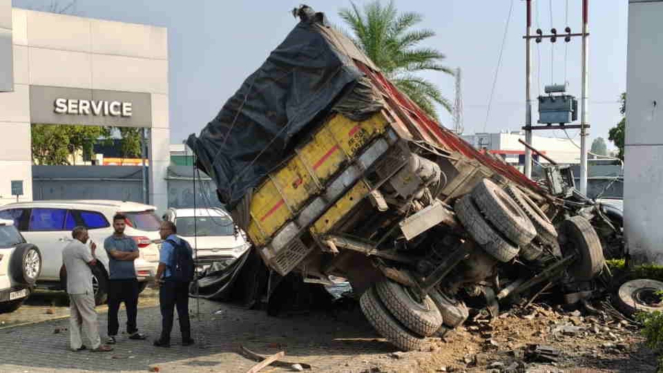 Dehradun News speeding truck crashed through the boundary wall of a car showroom, damaging several cars