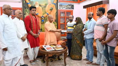 पीड़ित परिवार को आर्थिक सहायता सौंपते सीएम योगी