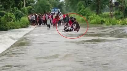 Young man narrowly escapes being swept away in a drain motorcycle washed away video viral on social media