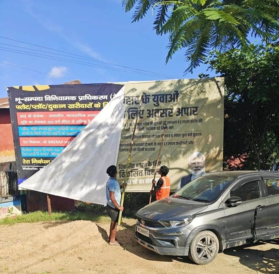 पोस्टर बैनर हटाते हुए कर्मी।