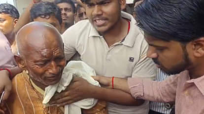 लाइन में रोते किसान को चुप कराते दूसरे किसान