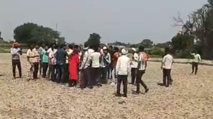 खेत में सचिव को पीटते किसान